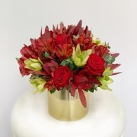 Celebration Hamper Flowers. Red and gold flowers in a gold pot.