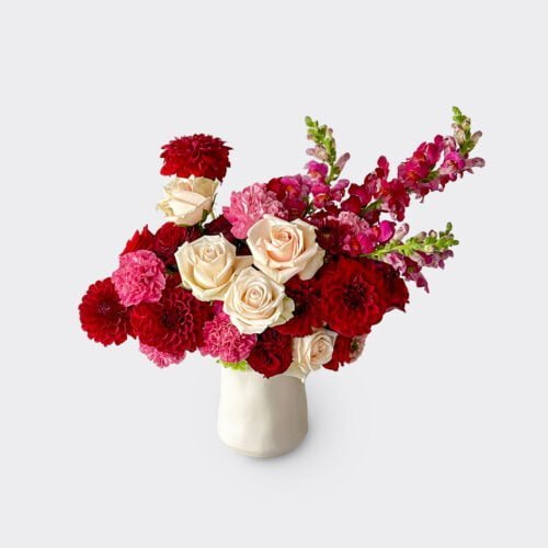 Bloom. Marmoset Found Tulip vase filled with red and pink flowers.